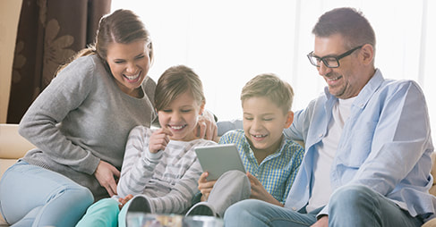 Cheerful family using tablet pc together in living room